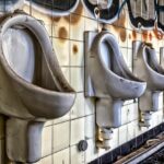 Macchie nere nel fondo della toilette con prodotti per la pulizia e spugna.