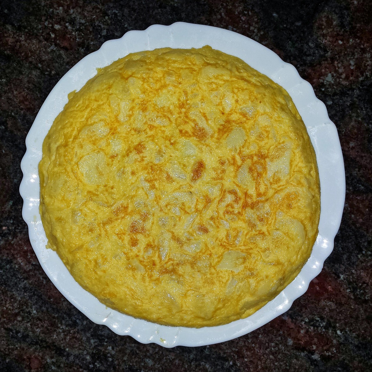 Frittata alta e soffice appena sfornata, con una doratura perfetta e ingredienti freschi.