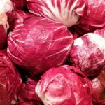 Un piatto di radicchio fresco, pronto per essere servito a cena, evidenziando il suo colore intenso e le foglie croccanti.