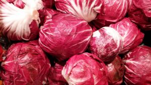 Un piatto di radicchio fresco, pronto per essere servito a cena, evidenziando il suo colore intenso e le foglie croccanti.