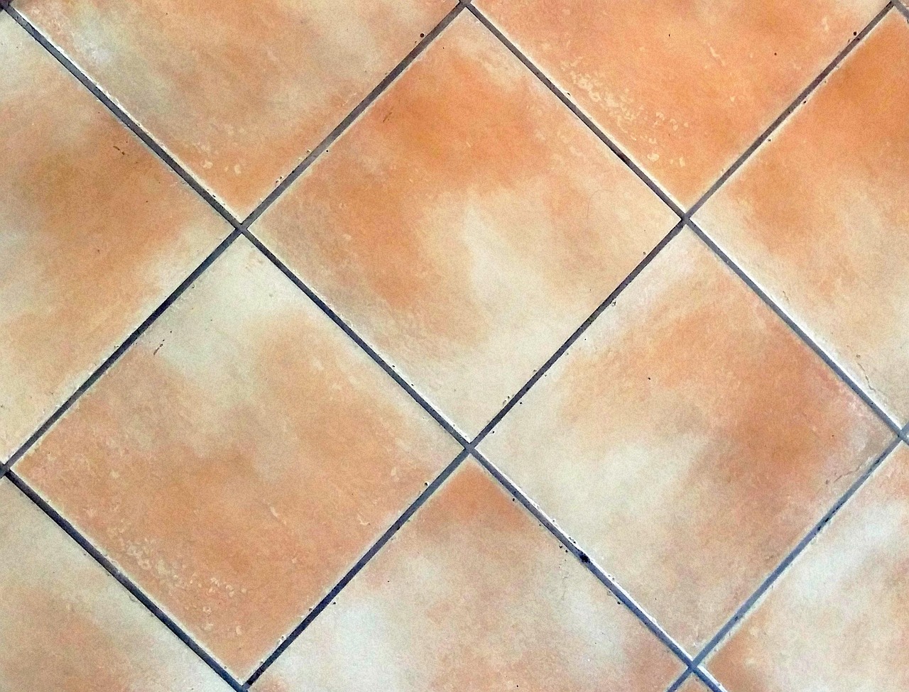 Pulizia delle fughe nere del pavimento con il metodo tradizionale della nonna.