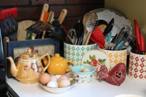 Cinque oggetti disordinati, simbolo di una casa non organizzata, su uno sfondo disordinato.