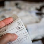 Persona anziana sorride felice mentre riceve una bolletta ridotta, simbolo di risparmio per over 70.